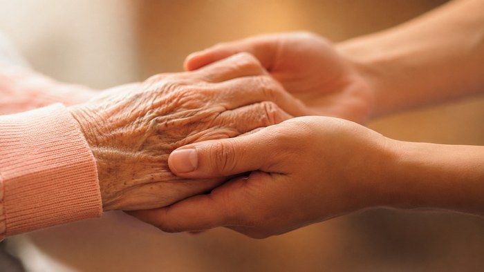 Zwei Hände halten sich – Symbol für Fürsorge und Vertrauen